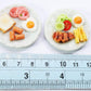Miniature Food Plates Set of 2 - Hand-Sculpted Clay Bread, Sausage, Egg & Pork Steak on Ceramic Dishes - 1:6 Scale Dollhouse Accessories