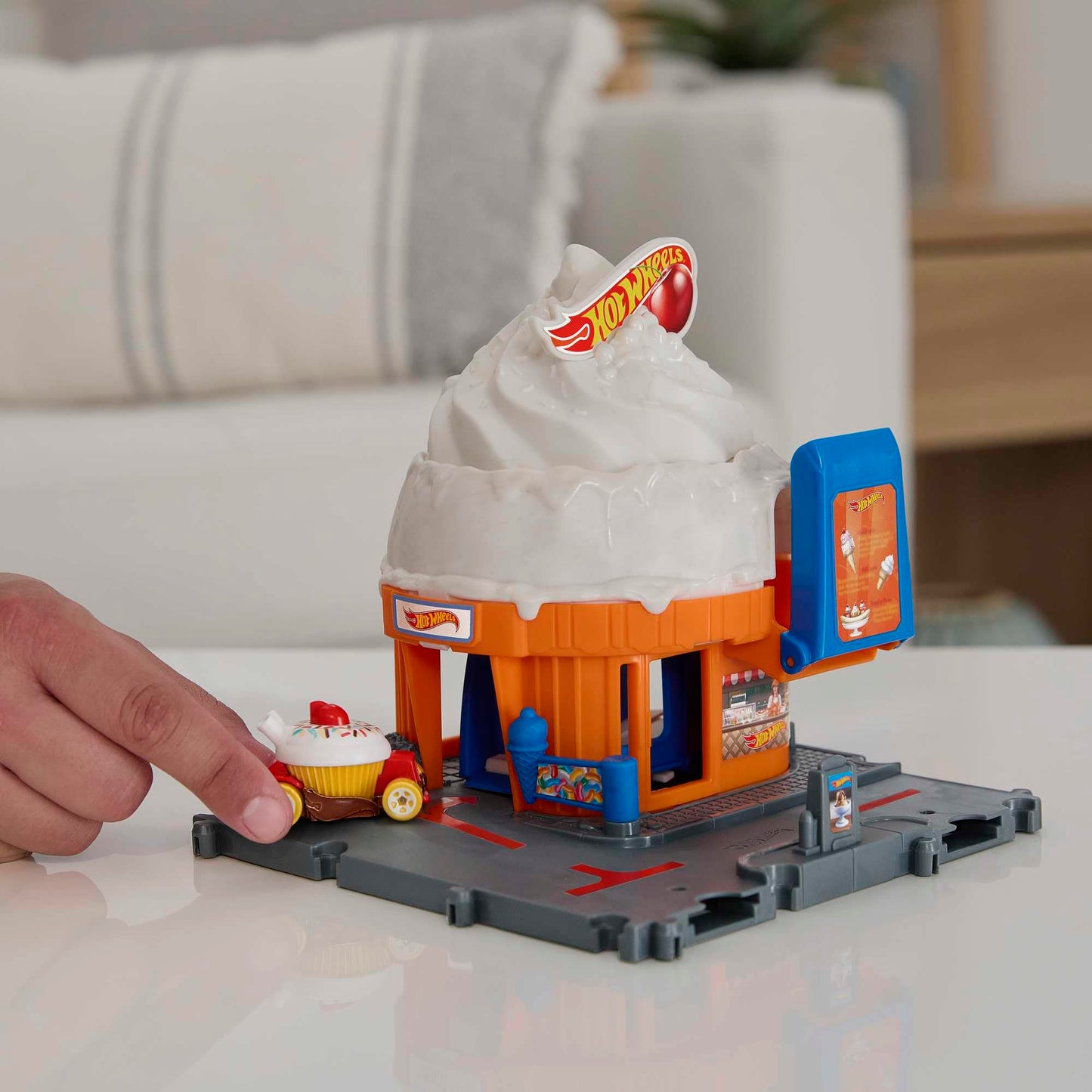 HOT Wheels City Downtown Spielset Eiskrem-Strudel - Rennbahn-Action mit manuellem Aufzug, Eiskrem-Wirbel und herunterklappbarer Rampe, inklusive 1 Hot