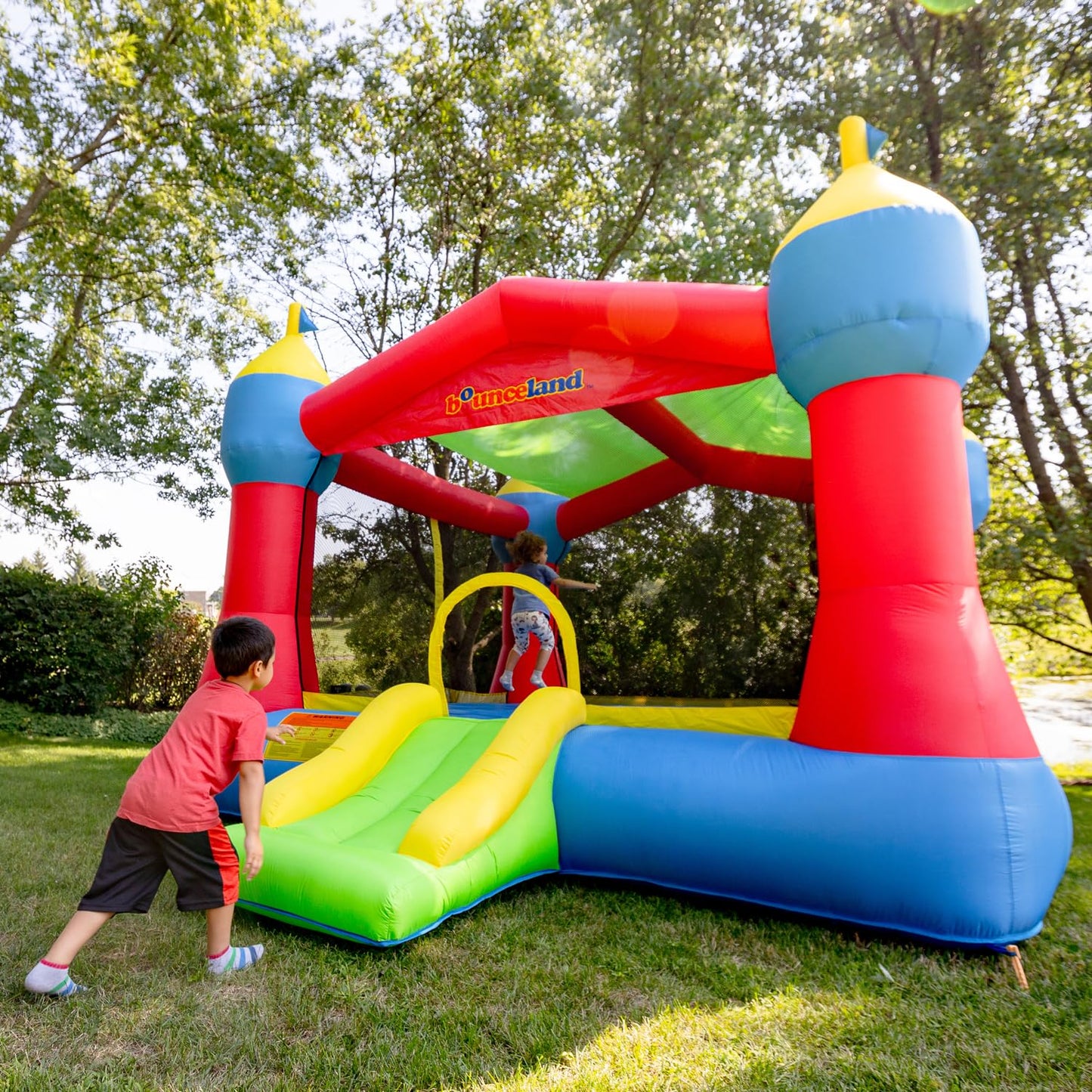 Bounceland Inflatable Party Castle Bounce House Bouncer, 16 ft L x 13 ft W x 10.3 ft H, Basketball Hoop, Removable Sun Roof, UL Strong Blower