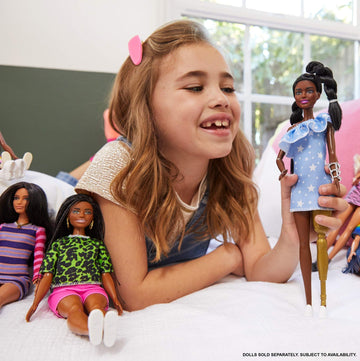 Barbie Fashionistas Doll #146 with 2 Twisted Braids & Prosthetic Leg Wearing Star-Print Dress, White Shoes & Arm Bracelet, Toy for Kids 3 to 8 Years